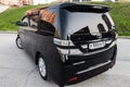 Rear View of Toyota Vellfire japanese luxury minivan car in black color on the parking with seven passenger seats Royalty Free Stock Photo