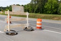 Rear view of a traffic barricade sign and orange and white traffic barrels, road closure, creative copy space