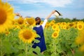 Rear view of travel lifestyle women with hands up hat in sunflower field, in summer day and happy vocations. Royalty Free Stock Photo