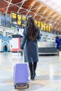 Traveler woman on a busy train station looking at the timetable screens Royalty Free Stock Photo