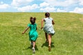 Rear view of two African girls running in a grass field Royalty Free Stock Photo