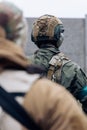 Rear view of two armed Ukrainian soldiers in uniform and helmets