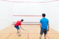 Rear view of two competitive young men playing squash game