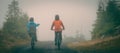 Rear view of two cyclists riding bikes in the park on a cold foggy day Royalty Free Stock Photo