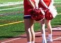 Two cheerleaders holding their red and white pom poms bshind their back Royalty Free Stock Photo