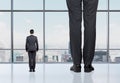 Rear view of two professionals in formal suites who stand in front of panoramic window Royalty Free Stock Photo