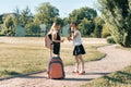 Rear view of two schoolgirl girlfriends with backpacks eating ice cream