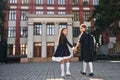 Rear view. Two schoolgirls is outside together near school building Royalty Free Stock Photo