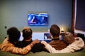 Rear view of two young affectionate homosexual couples watching movie Royalty Free Stock Photo