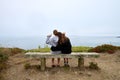 Rear view of two young female friends sitting on a beachside bench Royalty Free Stock Photo