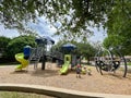 Rear view unidentified Asian kids playing with climbing structure at large playground with wood chips mulch, shade, slide and