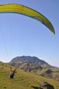 Rear view of unidentified male traveler enjoying paragliding with professional pilot in Himachal Pradesh.