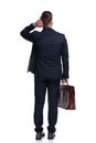 Rear view of an unsure businessman holding his suitcase Royalty Free Stock Photo