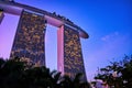 Rear view upshot of Marina Bay Sands hotel and casino against colorful tropical sunset, Singapore. Famous tourist