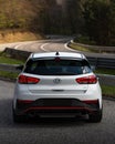 Rear view of a white 2020 Hyundai i30 on a winding road