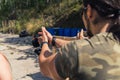 Rear view of white man in camo t-shirt practising how to aim handgun. Firearm training at firing range. Outdoor Royalty Free Stock Photo