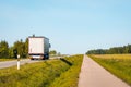 Rear view of white truck driving on the asphalt road in rural landscape Royalty Free Stock Photo