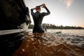 rear view of woman in black wetsuit in the water near the boat Royalty Free Stock Photo