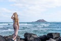 Rear view of woman with blonde hair looking at the infinity the sea