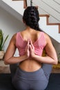 Rear view of woman doing reverse prayer yoga pose at home. Female yogi doing namaste mudra behind back. Vertical image Royalty Free Stock Photo