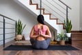 Rear view of woman doing reverse prayer yoga pose at home living room. Female yogi doing namaste mudra behind back. Royalty Free Stock Photo