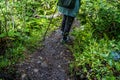 Rear view of woman engaged in nordic walking on rocky path. Royalty Free Stock Photo