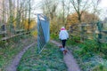 Rear view of a woman entering with her dachshund into Dutch natural ecological reserve