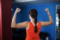 Rear view of woman flexing muscles in gym Royalty Free Stock Photo