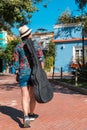 Rear view of woman with guitar bag walking in the park Royalty Free Stock Photo