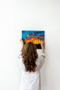 Rear view of woman hanging picture on the wall Royalty Free Stock Photo