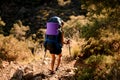 rear view of woman hiker with large backpack walking along the trail Royalty Free Stock Photo