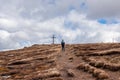 view of woman with hiking backpack reaching summit cross of mountain peak Gertrusk, Saualpe, Lavanttal Alps, Carinthia, Austria Royalty Free Stock Photo