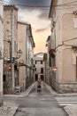 rear view of woman in long dress standing in middle of narrow street in old spanish town