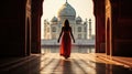 Rear view of woman looking at Taj Mahal, The magnificent Taj Mahal in India shows its full splendor at a glorious sunrise