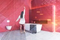 Woman in red bathroom with tub and toilet Royalty Free Stock Photo