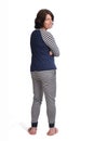 Rear view of a woman in pajamas on white background, arms crossed and looking at camera Royalty Free Stock Photo