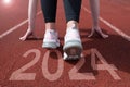 woman preparing to start on an athletics track engraved with the year 2024 Royalty Free Stock Photo
