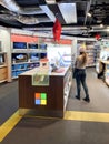 Rear view of Woman shopping Multiple Microsoft Surface tablets and notebooks for sale at dedicated Microsoft stand