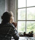 Rear view of woman sitting thoughtful lookout of the window Royalty Free Stock Photo