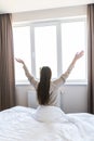 Rear view of woman stretching in bed after wake up in morning Royalty Free Stock Photo