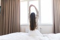 Rear view of woman stretching in bed after wake up in morning Royalty Free Stock Photo