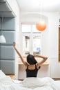 Rear view of woman stretching in bed after wake up in morning Royalty Free Stock Photo