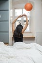 Rear view of woman stretching in bed after wake up in morning Royalty Free Stock Photo