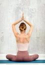 Rear view of a woman in the Sukhasana yoga pose