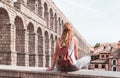 rear view of woman tourist enjoying view of Roman aqueduct on plaza del Azoguejo in Spain