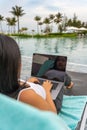 Rear view of woman using laptop at swimming pool Royalty Free Stock Photo