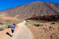 Rear view on woman walking on panoramic hiking trail leading to Pico del Teide in volcano Mount Teide National Park, Tenerife