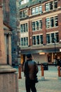 Rear view of a woman walking on the street of Manchester City Centre, UK