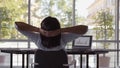 Rear view of woman working on computer in office stretching at desk Royalty Free Stock Photo