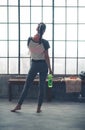 Rear view of woman in workout gear in loft gym holding water Royalty Free Stock Photo